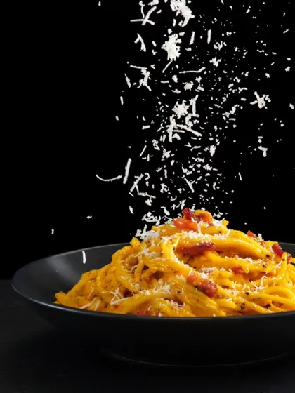 A beautifully plated bowl of pasta, generously topped with freshly grated parmesan cheese. This image represents our ability to create gourmet Italian dishes that are both authentic and visually appealing.