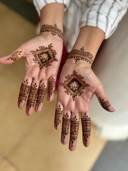 A simple yet striking design with a diamond-shaped lotus motif on the palm and detailed finger caps.