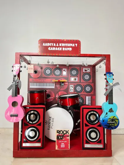 Ready to rock! This 'Garage Band' themed hamper for twins Aadiya and Krishna features a complete miniature drum set, speakers, and guitars.