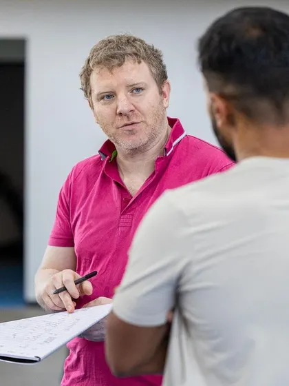 A trainer provides feedback to a participant during a practical assessment, ensuring clear communication and understanding.
