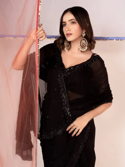 A classic black saree look, styled for an e-commerce catalogue. The lighting is designed to show the texture and sparkle of the fabric.