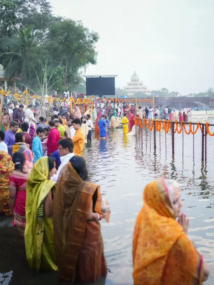 A wide shot of the Chhath Puja gathering, with many devotees standing in the water. We create a dedicated, clean water body for this festival at our Bengaluru ashram.