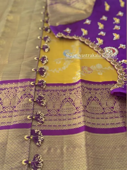 A purple blouse with mango butis and a matching border with tiny tassels.
