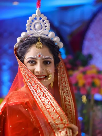 A classic portrait of a beautiful Bengali bride, showcasing her traditional 'mukut' and bridal makeup.