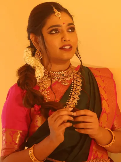 This hairstyle features a loose, textured side braid with fresh jasmine flowers woven in. It's a beautiful fusion of modern and traditional, perfect for a pre-wedding event.