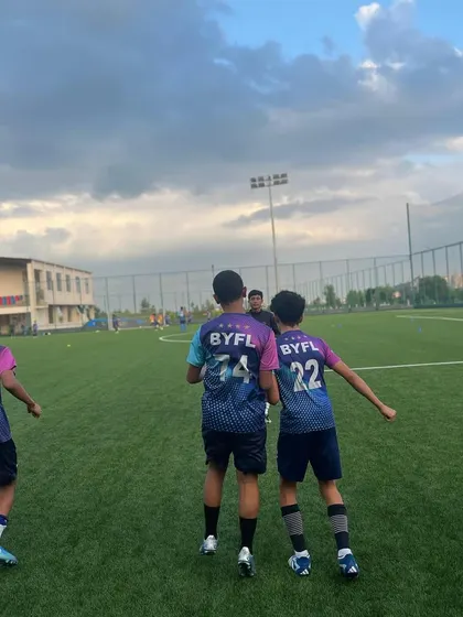 Players seen from behind, showcasing their official BYFL jerseys during a training run.