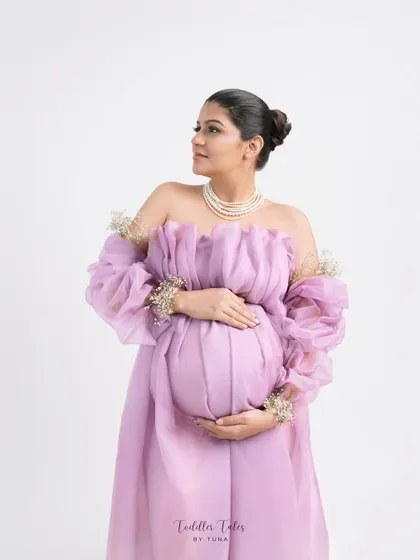 A portrait of regal elegance. The off-shoulder lavender gown, pearl necklace, and delicate floral details on the sleeves create a look fit for a queen.