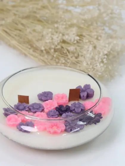 Another beautiful floral creation for Women's Day. This low, wide glass bowl candle is decorated with pink and purple flower wax melts, creating a lovely miniature garden of light.