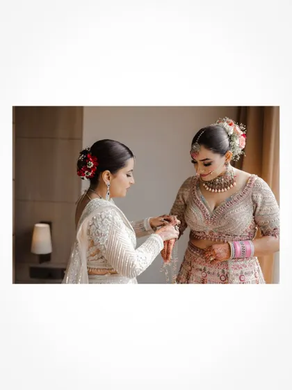 A touching moment as the bride's sister helps her get ready.