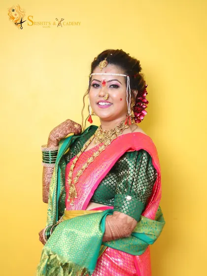 Our beautiful bride in her vibrant 'Marathi Saaj'. We used a color palette that complements her pink and green saree, ensuring she looks bright and festive for her special day.