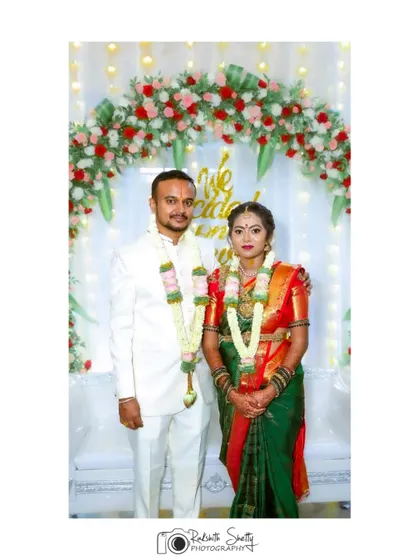 A classic wedding portrait of the couple in their traditional South Indian attire. Posing in front of a floral backdrop, this photo is a timeless keepsake of their wedding day.