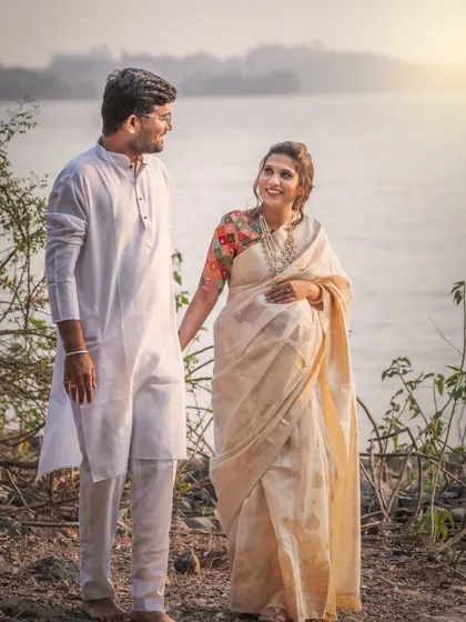 A happy, candid moment between an expecting couple during their outdoor maternity shoot by the water. Their joyful interaction and the beautiful scenery create a light and airy portrait.