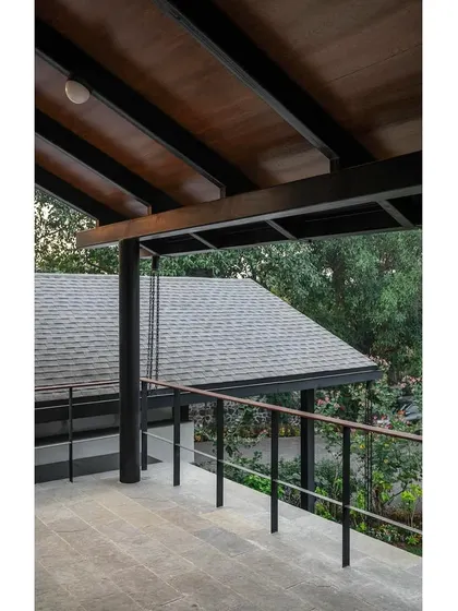 The upper balcony at Grove House, showing the detail of the steel railing and the wooden ceiling of the veranda below.