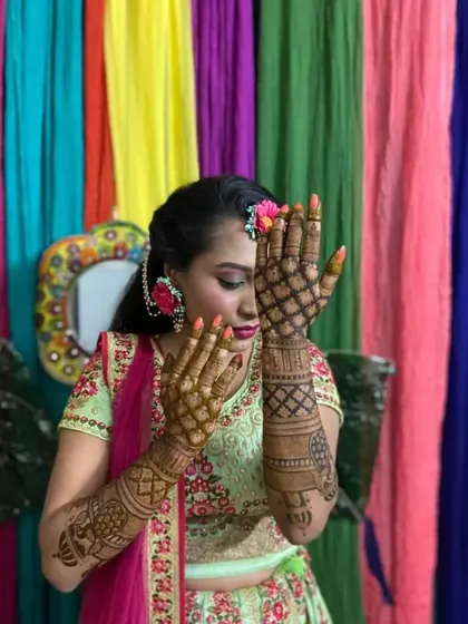 This bride chose a delicate jaali pattern for the back of her hands. The design is paired with floral jewelry, showing how well the mehndi complements bridal accessories.