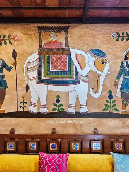 The centerpiece of the interior wall is this majestic white elephant carrying a deity, part of a temple procession mural that adds a regal touch to the living area.