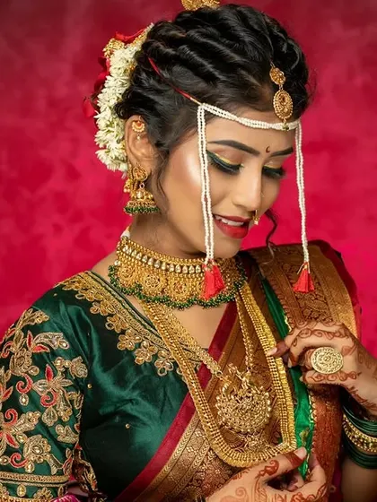 The quintessential Maharashtrian bride. This look features the traditional 'mundavalya', a crescent-shaped bindi, and a nauvari saree, all brought together with makeup that highlights her natural Marathi beauty.