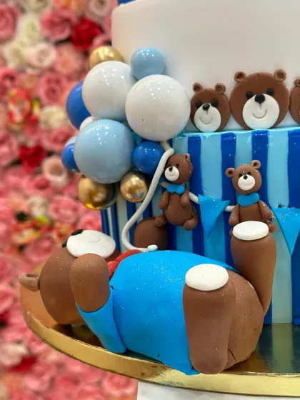 A close-up of the detailed fondant work on the teddy bear cake, showing the texture of the bears and the balloon decorations.