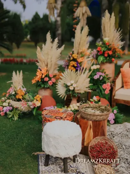 More details from the Marrakesh Mehendi, with earthy terracotta pots, pampas grass, and a variety of seating options like macrame stools and patterned ottomans.
