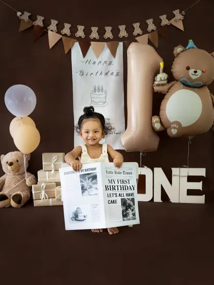 He's the star of the show! Holding up his personalized birthday newspaper, this little one is ready to celebrate his first year.