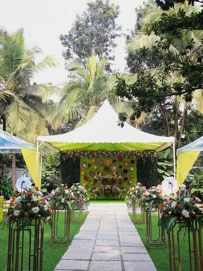 A vibrant naming ceremony setup at Farmhouse Collective. The bright green drapes and colorful backdrop create a festive and cheerful atmosphere for celebrating a new arrival.