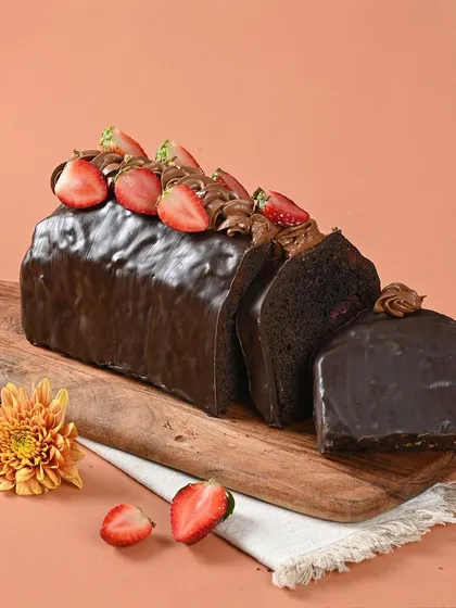 Perfectly dense, perfectly delicious. This is our rich chocolate loaf cake, topped with fresh strawberries. It's a decadent treat for any chocolate lover.