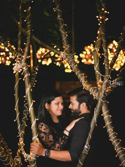 A close-up, intimate portrait of a couple among the fairy-lit trees.