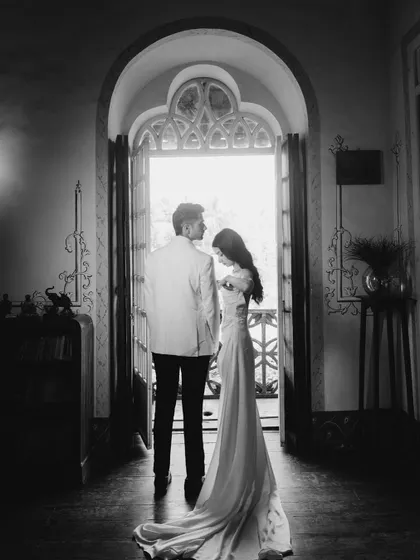 A dramatic and romantic silhouette of Sahil and Khushali framed by a grand archway. This black and white image is timeless, focusing on their connection and the beautiful light.