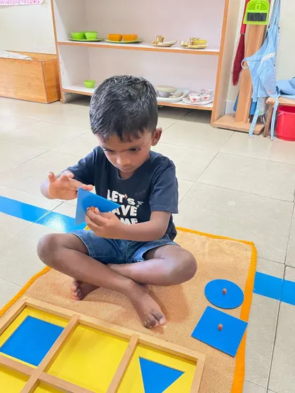 Working with the geometric insets from the cabinet, this child is developing a muscular memory of each shape. This tactile exploration is a key part of how we move from concrete understanding to abstract thought in geometry.