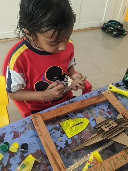 Another young artist meticulously painting the small parts of his airplane model. We use non-toxic, kid-safe paints for all our art projects.
