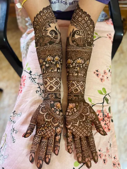 This full-arm design is packed with traditional elements, including rows of elephants, blooming lotuses, and majestic peacocks, all framed by intricate borders.