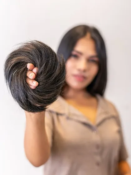 Our Donut Bun, made from 100% real human hair, is perfect for creating a full, elegant bun in seconds. This model showcases the volume and quality of the hairpiece.