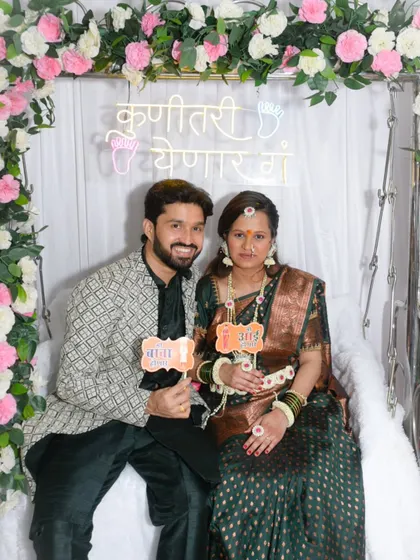 The happy couple holding "Mama" and "Baba" props during their baby shower. These fun signs add a personal and cute touch to the photos.