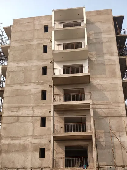 The raw concrete facade of a multi-story building. This shows the structure after the main frame is complete but before plastering or painting.