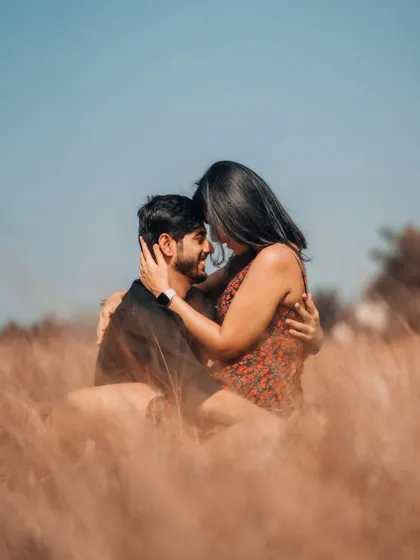 An intimate embrace during a pre-wedding shoot in a golden field, showcasing a tender and romantic connection.