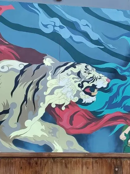 The left side of the Mysore mural, focusing on the spirit tiger emerging from Mother Nature. The dynamic pose and stylized form of the tiger create a sense of mythic power and movement.
