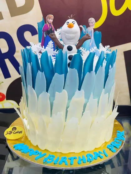 A unique 2.5kg Frozen theme cake with Olaf surrounded by shards of white and blue chocolate.
