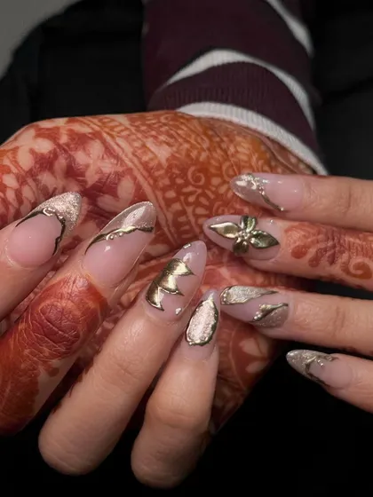 Another view of these luxurious gold bridal nails, showing how the metallic elements catch the light. This is a look fit for a queen.