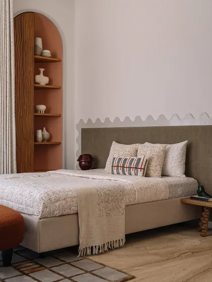 A closer look at the guest bedroom, with its warm, earthy tones, custom-printed bedding, and a cozy nook for reading.