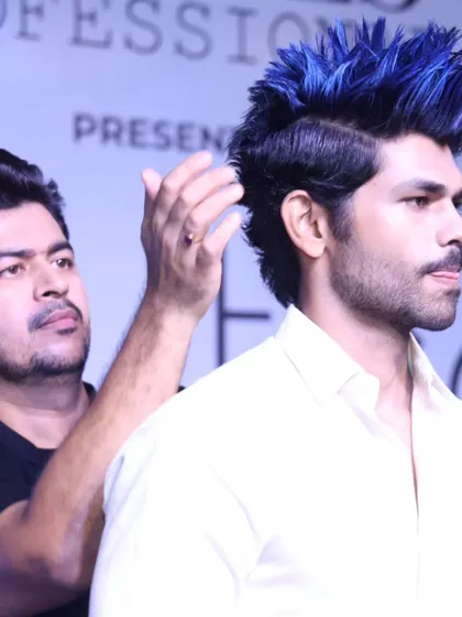 Here I am on stage at a hair expo, creating a bold, edgy look with electric blue color and a spiky style for a male model.