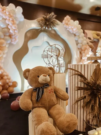 A cute teddy bear prop sitting amongst the stylish decor, adding a touch of softness to the modern theme.
