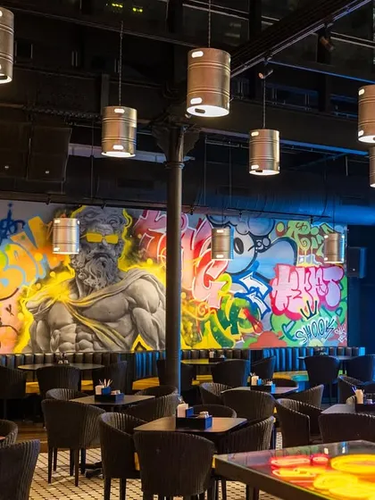 The entire restaurant space, showing how the murals become the main feature of the interior design. The art sets the whole mood.