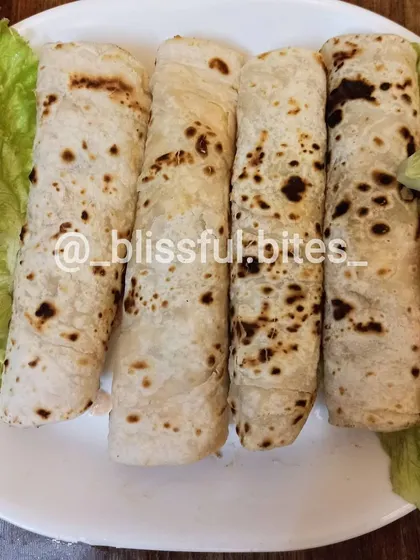 My Smokey Chicken Rolls, filled with flavourful chicken and wrapped in a soft, flaky flatbread. They are served here with a side of fresh salad.