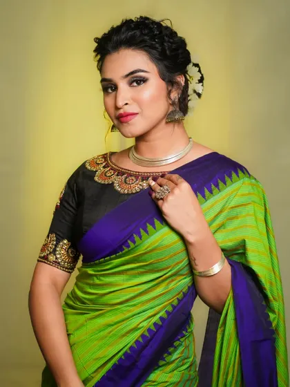A close-up of the same look, focusing on the elegant blouse design and the model's confident expression.