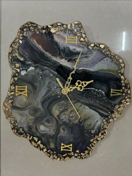 A close-up of a dark, marbled geode clock, showing the intricate patterns that can be created by blending different resin colors.