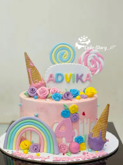 A pastel-colored cake for Advika's 4th birthday. This pretty cake is decorated with a rainbow, ice cream cones, lollipops, and delicate floral details.