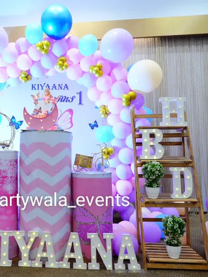 A close-up of the details from Kiyaana's butterfly party, including the 'HBD' shelf and themed pedestals.