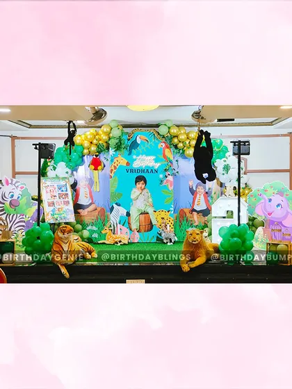 I designed this expansive jungle safari stage to create a wild adventure for a second birthday. The setup includes a personalized backdrop, numerous life-sized animal cutouts like a tiger, elephant, and giraffe, and lush green and gold balloon arrangements to complete the jungle vibe.