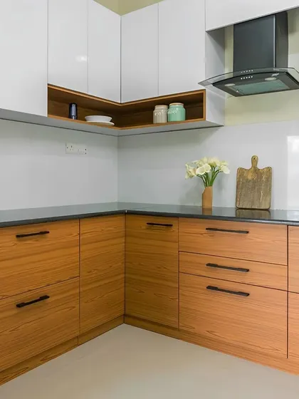 This kitchen showcases a classic two-tone combination of wood-finish lower cabinets and white upper cabinets. The design is clean and timeless, with black hardware adding a modern touch.