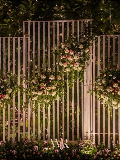 A modern photo backdrop made of white slatted panels, adorned with clusters of white and pink florals. This provided a clean and contemporary spot for photos.