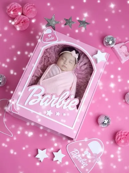 A perfect little doll in her box. The Barbie theme is a fantastic way to create a memorable and shareable announcement photo for your baby girl.